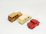 three toy cars and a bus on a white surface