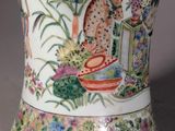a vase with a painting on it sitting on a table