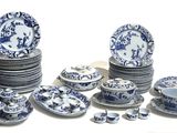 a lot of blue and white plates and bowls on the table