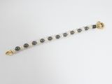 un gros plan d'un bracelet en perles posé sur une surface blanche