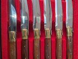 cinq couteaux dans une boîte rouge aux manches dorés