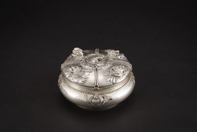 une boîte ancienne en argent ornée de fleurs sur fond noir