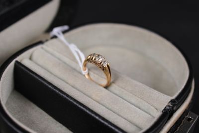 une bague en or dans un écrin noir orné d'un ruban blanc