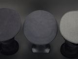 three different colors of speakers sitting on top of a black surface