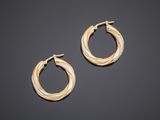 a pair of gold hoop earrings on a black background