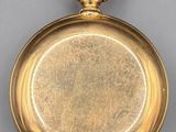 an old gold pocket watch with a chain hanging from it ' s side
