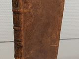 an old brown book sitting on top of a glass table