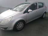 a picture of a silver car parked in front of a garage