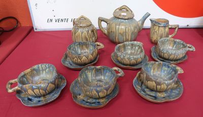 a table with a red table cloth and a set of teapots and cups and saucers