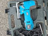 a blue corded drill in a case on the ground
