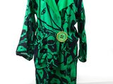 green and black robe on a mannequin stand with a white background
