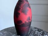 un vase noir et rouge posé sur une table en marbre