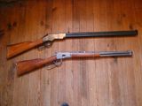 deux fusils de chasse posés côte à côte sur un plancher en bois