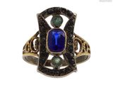 une image représentant une bague ornée d'une pierre bleue entourée de pierres vertes