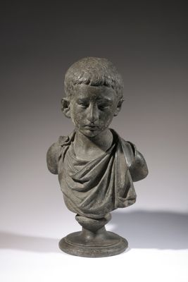 a close up of a statue of a boy on a pedestal