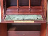 an old wooden desk with a marble top in a room