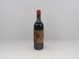une vieille bouteille de vin posée sur une table blanche