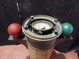 a compass on top of a wooden stand with balls around it