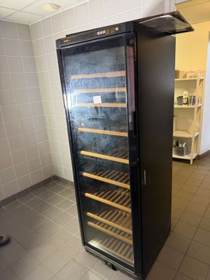 a wine cooler that is in the middle of a room