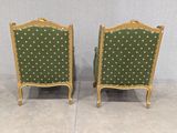 pair of green upholstered chairs with gold trim and dots