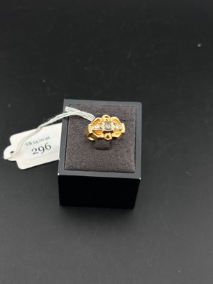 une bague en or ornée d'une fleur, posée sur un coffret noir