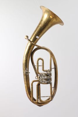 an antique brass french horn on a white background