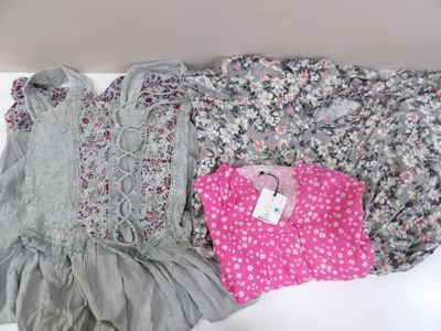 trois paires de vêtements pour petite fille posées sur une surface blanche