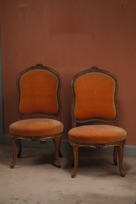 une paire de fauteuils rembourrés orange devant un mur rouge