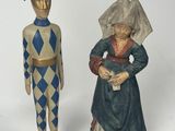 two figurines of a man and a woman standing next to each other