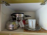 une photo d'un placard de cuisine contenant des casseroles et des poêles