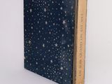 an old book sitting on top of a white surface covered in stars