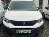 une camionnette blanche garée dans un parking à côté d'autres voitures