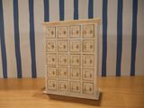 a small wooden chest of drawers on a wooden table