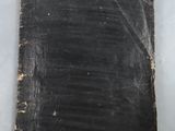 a close up of a piece of black paper with a blue tag on it