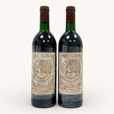 deux bouteilles de vin rouge posées l'une à côté de l'autre sur une surface blanche