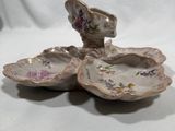 pair of porcelain dishes with flowers on them sitting on a white surface
