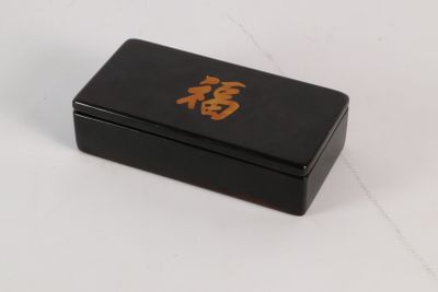 une petite boîte noire sur laquelle figure une inscription en caractères orientaux