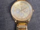 a gold fossil watch on a blue cloth