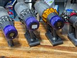 several vacuums are lined up on a wooden table