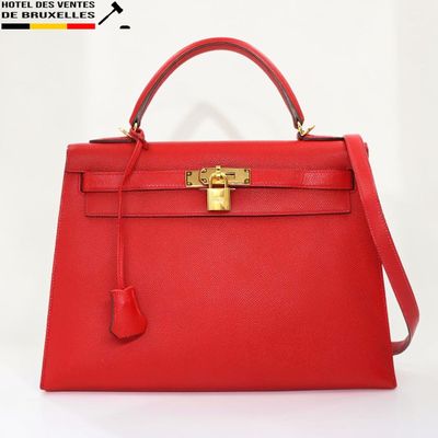 un sac à main en cuir rouge muni d'un fermoir doré sur la poignée