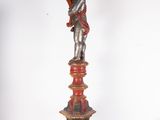 a statue of a man holding a bird on a pedestal