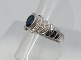 un gros plan d'une bague en argent sertie d'une pierre bleue
