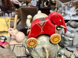 a red toy elephant sitting on top of an elephant statue