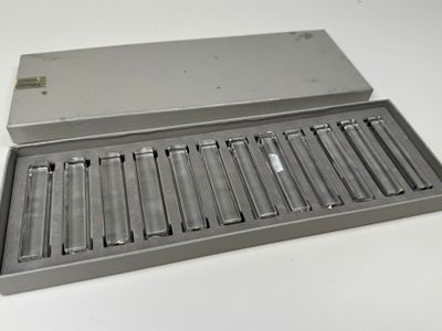 une boîte métallique contenant six piles, posée sur une table