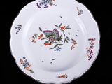 une assiette sur laquelle est représenté un papillon sur fond noir