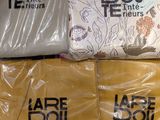 three shirts are wrapped in plastic and sitting on top of each other