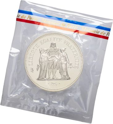 a close up of a coin in a plastic bag on a white background
