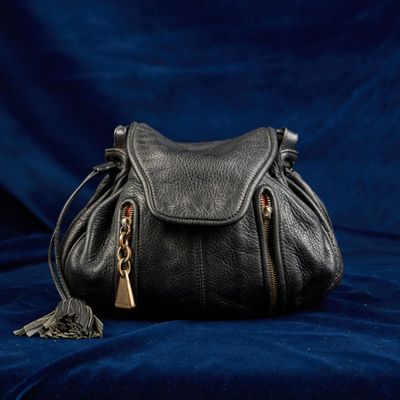 un sac à main noir posé sur un tissu bleu