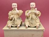 paire de figurines chinoises représentant un garçon et une fille assis sur une boîte
