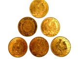 six gold coins are arranged in a pyramid on a white surface